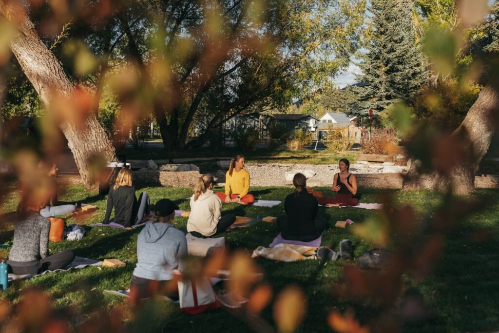 A group of women enjoy a yoga retreat outdoors.